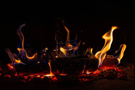 Foto de Leña en llamas en la acogedora tierra: las llamas parpadean en la chimenea rústica - Imagen libre de derechos