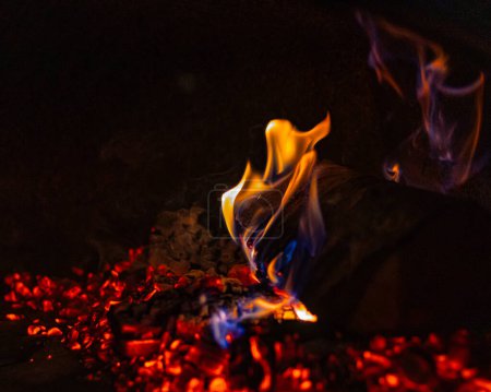 Foto de Las llamas crepitantes de la quema de troncos de madera en el ajuste tradicional de la chimenea - Imagen libre de derechos