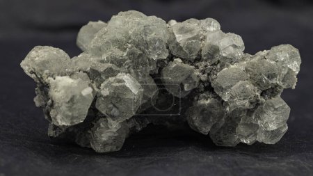 Macro shot de cristaux de fluorite translucides affichant une structure cubique sur fond sombre