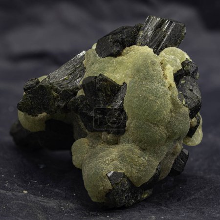 Este cautivador espécimen presenta la textura botrioidal de la prehnita y el tono verde brillante, acentuado por inclusiones minerales oscuras