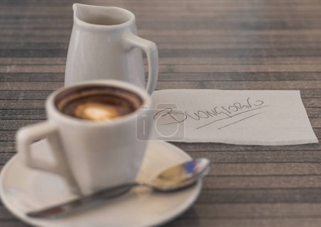 escena del café de la mañana, con un espresso recién hecho junto a una crema en una mesa de madera, con 'Buongiorno' dando la bienvenida al día, invitando a un momento de reflexión pacífica