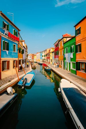 Photo for Burano, Italy - October 2022: Canal with boats and characteristic colorful houses of Burano with tourists - Royalty Free Image