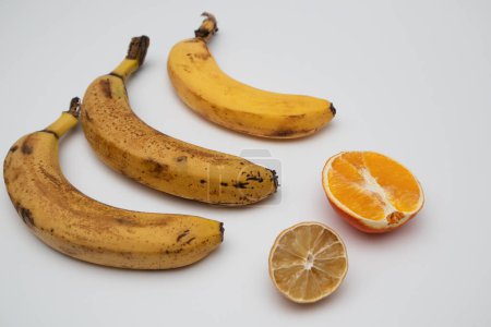 Photo for Rotten ripe bananas, half orange and lemon Excessive consumption, wasting money - Royalty Free Image