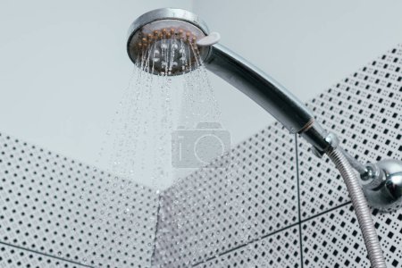 Silver shower head with limescales. Shower damaged from water scale. Hard water deposit all around the sprinklers