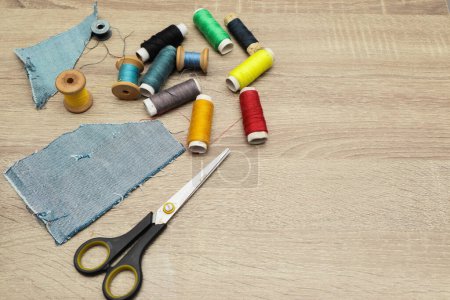 Scissors and sewing supplies on desk. Directly above shot of sewing items on wooden background. Tools and accessories for sewing