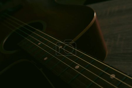 Photo for Close up of a acoustic guitar string and fingerboard with new strings. Photo of a old wooden guitar with steel strings. Strings close up. - Royalty Free Image