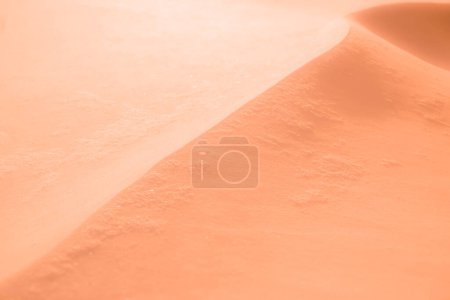 Peach Fuzz background. Dune of sand. Abstract blurred background in trendy color 2024.
