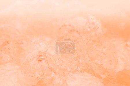 Abstrakte Nude und Pfirsichfarbverlauf Hintergrund. Wasseroberfläche. Klare Oberflächenstruktur des Wassers mit Spritzern und Blasen. Abstrakter Pfirsichhintergrund.