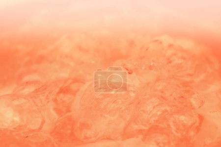 Abstract nude and peach fuzz color gradient background. Water surface. Clear water surface texture with splashes and bubbles. Abstract peach background.