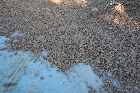 Geotextile layer between gravel. White Geotextile with gravel lies on a construction site. Modern construction technologies and materials. Driveway for construction equipment, empty Road