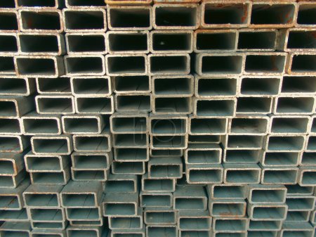 Photo for New square metal pipes in stock. Rolled metal products. Construction or manufacturing materials concept. Steel products, metal pipes - Royalty Free Image
