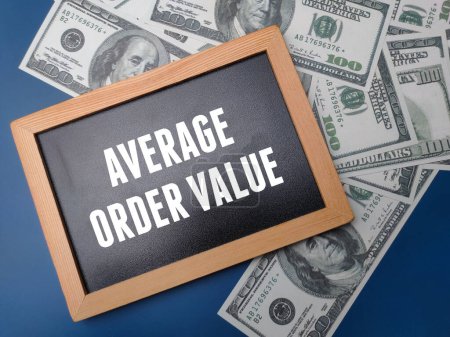 Black wooden board and banknotes with the word AVERAGE ORDER VALUE on a blue background