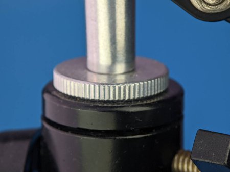 Téléchargez les photos : Closeup microphone mounting screw on a blue background. - en image libre de droit