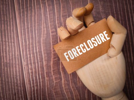 Photo for Wooden hand holding card board with the word FORECLOSURE. - Royalty Free Image