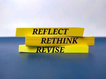 Livre jaune avec le mot REFLECT RETHINK REVISE. Concept d'entreprise.