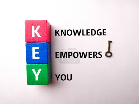 Foto de Bloque de madera de color con la palabra KNOWLEDGE EMPOWER YOU sobre fondo blanco. Concepto empresarial. - Imagen libre de derechos