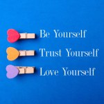 Wooden clips with the word Be yourself Trust yourself Love yourself on a blue background