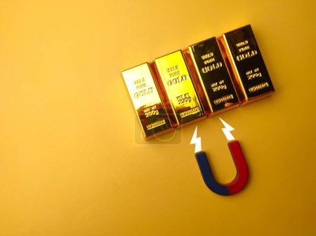 Photo for Top view magnet attract the gold bar on a yellow background. - Royalty Free Image