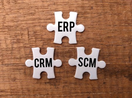 Photo for Top view white puzzle with the word ERP CRM SCM on a wooden background. - Royalty Free Image