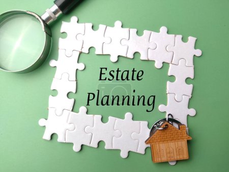 Puzzle,magnifying glass and wooden house with the word Estate Planning on green background.