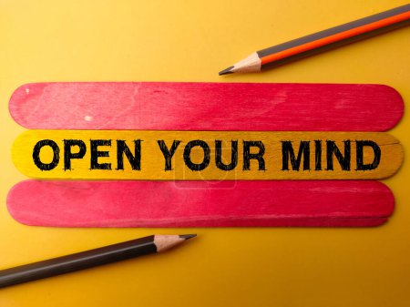Photo for Colored stick and pencil with the word OPEN YOUR MIND on yellow background - Royalty Free Image