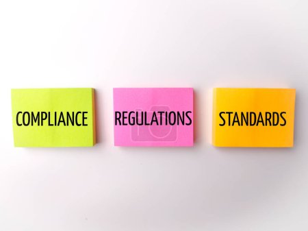 Photo for Colored sticky note with the word COMPLIANCE REGULATIONS STANDARDS on white background - Royalty Free Image