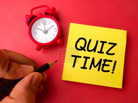 Photo for Alarm clock and sticky note with the word QUIZ TIME on a red background - Royalty Free Image