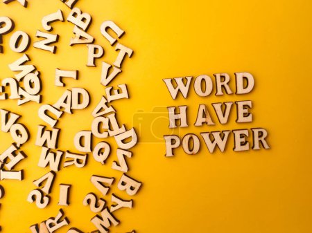 Téléchargez les photos : Jouet de lettre en bois arrangé le mot WORD HAVE POWER avec un fond jaune. - en image libre de droit