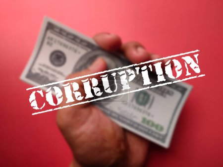 Téléchargez les photos : Quelqu'un tenant des billets de banque avec le mot CORRUPTION sur fond rouge - en image libre de droit