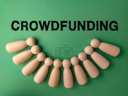Photo for Wooden peg doll with the word CROWDFUNDING on a green background. Crowdfunding concept. - Royalty Free Image