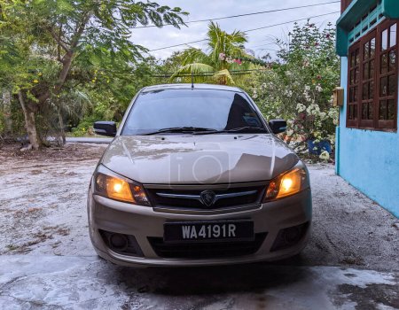 Téléchargez les photos : Pantai Remis, Perak, 9 juillet 2023 : Une voiture garée devant une maison sous un arbre. - en image libre de droit