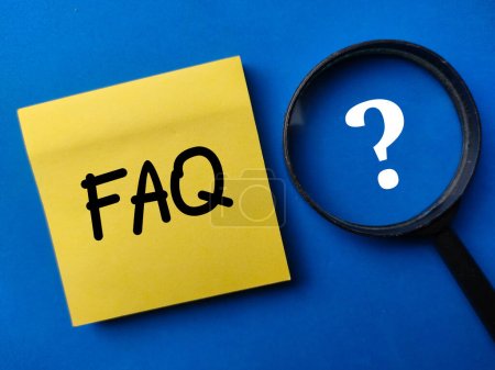 Foto de Magnifying glass and sticker note with the word FAQ on a blue background - Imagen libre de derechos