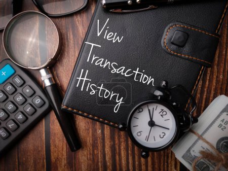 Lupe, Banknoten und Taschenrechner mit dem Wort Transaktionshistorie anzeigen.