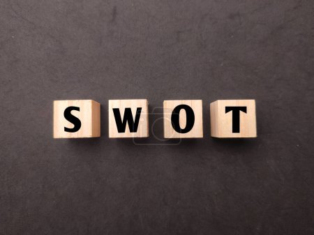 Photo for Top view wooden cube with the word SWOT on black background. - Royalty Free Image
