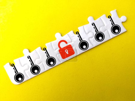 Photo for A white puzzle with a key and lock icon with an open red lock. the concept of safety - Royalty Free Image