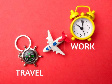 Foto de Brújula vista superior, juguetes avión y reloj con texto Travel Work sobre fondo rojo. - Imagen libre de derechos
