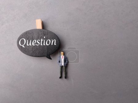 Foto de Tablero de conversación de vista superior y personas en miniatura con texto Pregunta sobre fondo gris. - Imagen libre de derechos