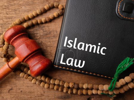 Téléchargez les photos : Perle de prière, marteau et cahier avec texte Loi islamique sur fond en bois. - en image libre de droit