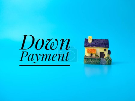 Photo for Miniature house with text Down Payment on blue background. - Royalty Free Image