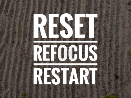 Inspirational and motivational quote on sand background. RESET REFOCUS RESTART.