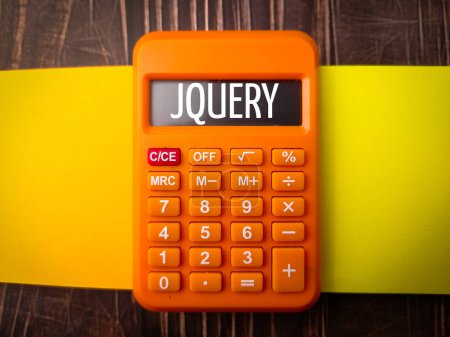Top view colored notebook and calculator with text JQUERY on wooden background