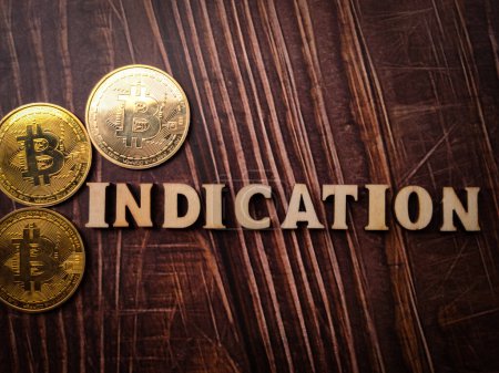 Top view bitcoins and wooden word with text INDICATION on a wooden background.