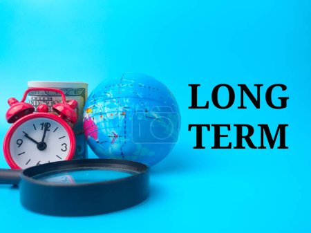 Photo for Magnifying glass,earth globe,banknotes and clock with text LONG TERM on blue background. - Royalty Free Image
