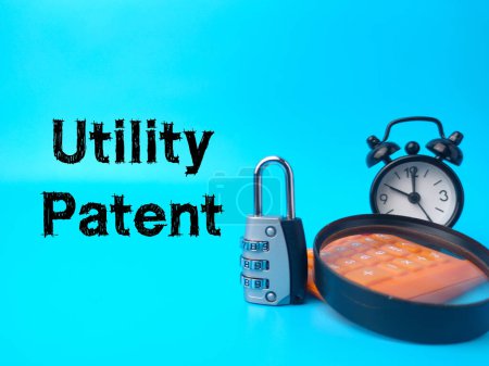 Padlock,magnifying glass,calculator and clock with text Utility Patent on blue background.
