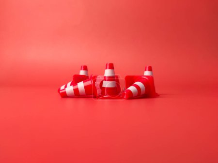 Téléchargez les photos : Mini cônes en plastique Sport Training sur un fond rouge qui a été dispersé. - en image libre de droit