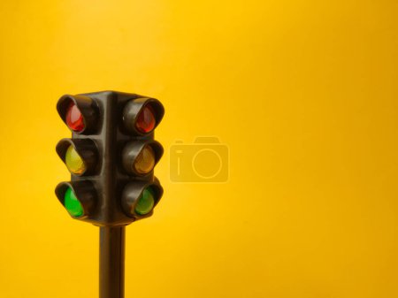 Mini traffic lights on a yellow background with copy and text space.