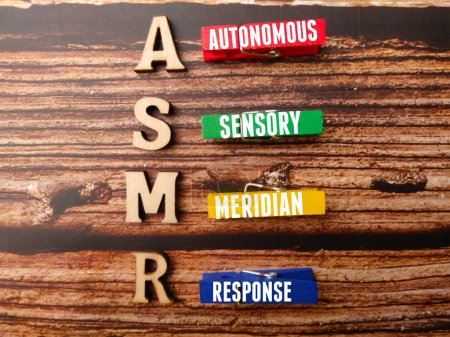 Top view wooden clips with text ASMR on a wooden background.