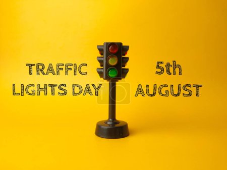 Traffic light with text TRAFFIC LIGHT DAY 5TH AUGUST on a yellow background.