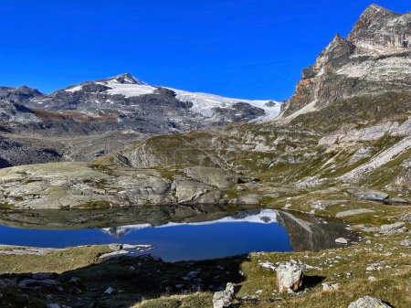 Reflexiones sobre hielo alpino: Vistas panorámicas al lago glaciar, Altos Alpes, Francia