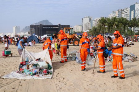 Foto de Los trabajadores limpian basura en la playa de Copacabana después del Show de Nochevieja. Enero 01, 2023, Rio de Janeiro, Brasil: Empleados de Comlurb han estado trabajando desde temprano para eliminar toneladas de basura de las arenas de la playa de Copacabana. - Imagen libre de derechos